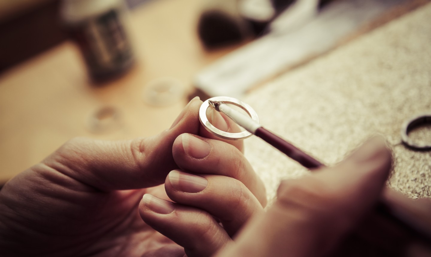 Couple learning from experienced jeweller in the Brisbane studio as they make their own wedding rings
